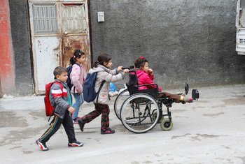 上的残疾难民女孩在姐姐帮助下和其他兄弟姐妹前往土耳其阿达纳上学